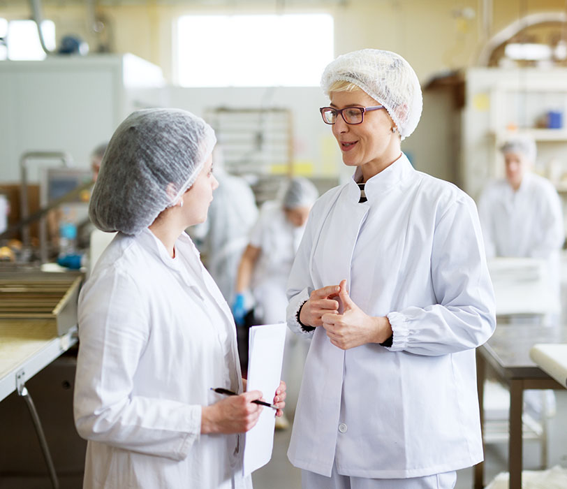 Female workers conversing in commercial kitchen