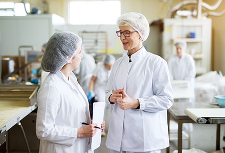 Female workers conversing in commercial kitchen