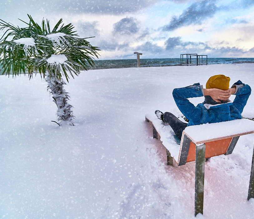 Person resting on a snowy tropical beach