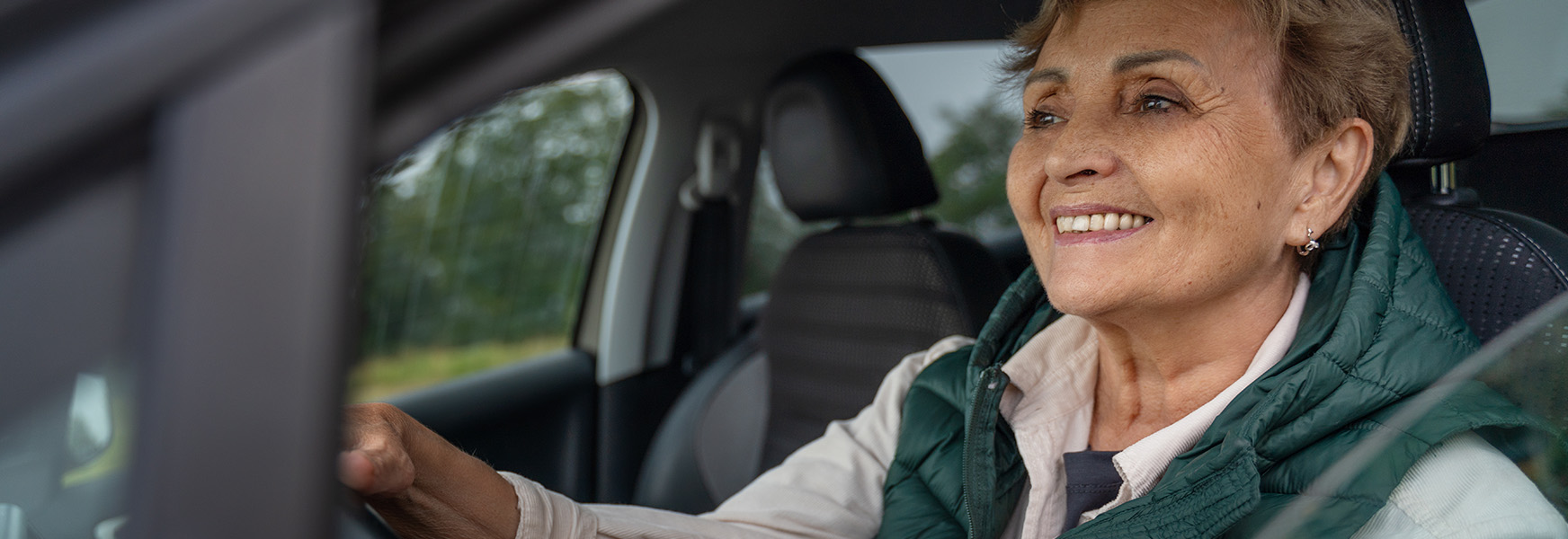 Smiling senior woman driving a car