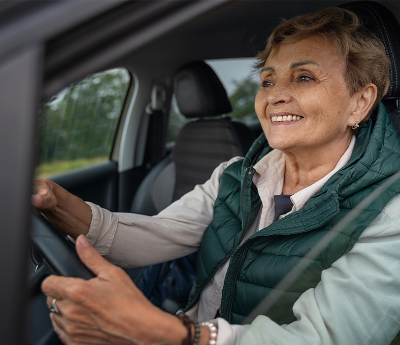 Smiling senior woman driving a car