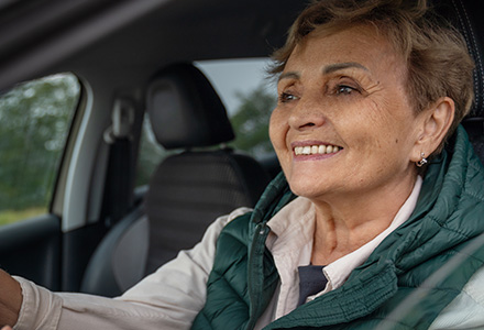 Smiling senior woman driving a car