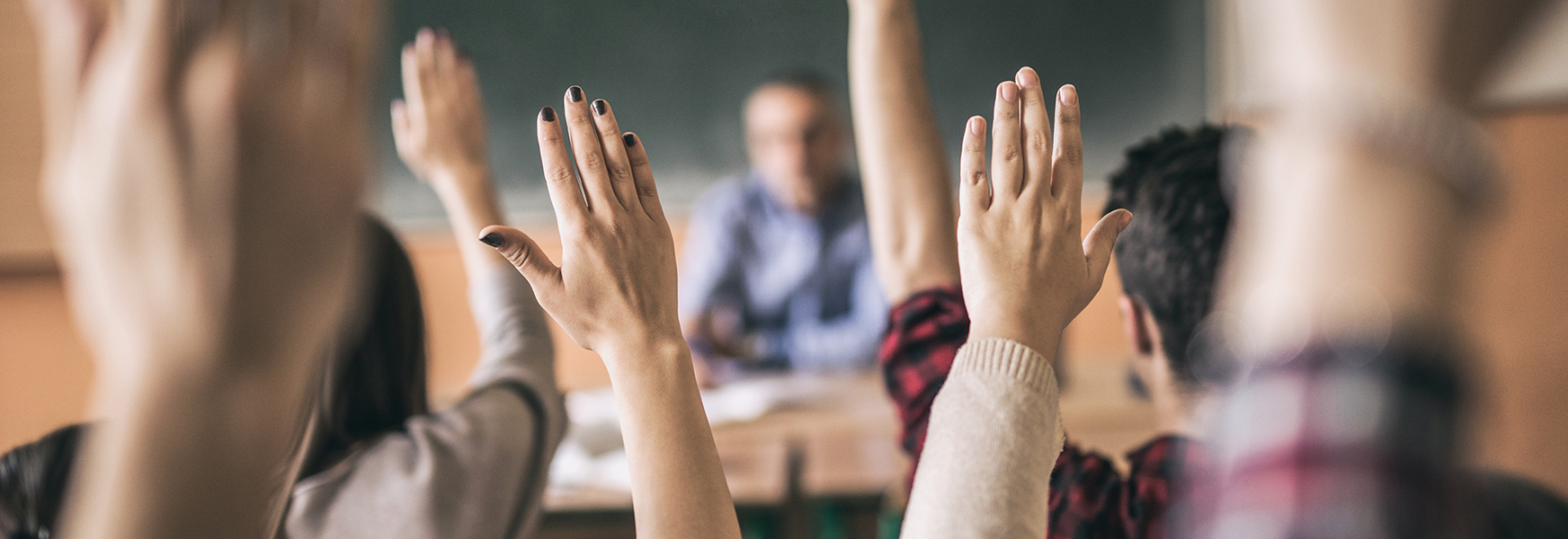 Kids in classroom raising hand