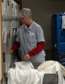 Laundry worker taking laundry out.