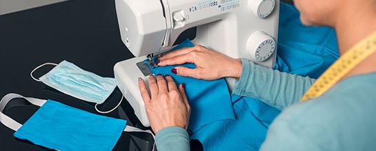 Woman making homemade masks on sewing machine