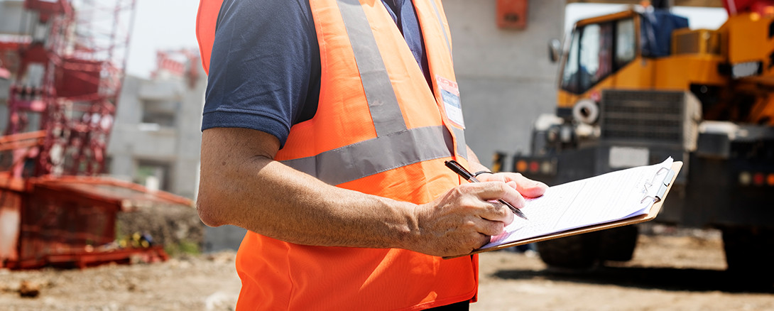 man on construction site with safety checklist