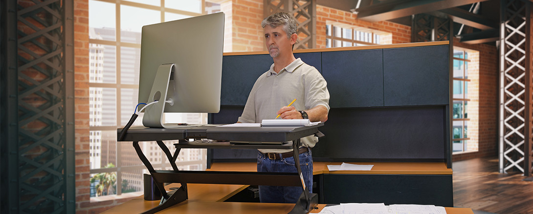 worker at sit/stand ergonomic workstation