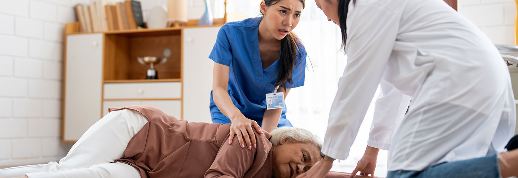 Healthcare workers assisting fallen resident