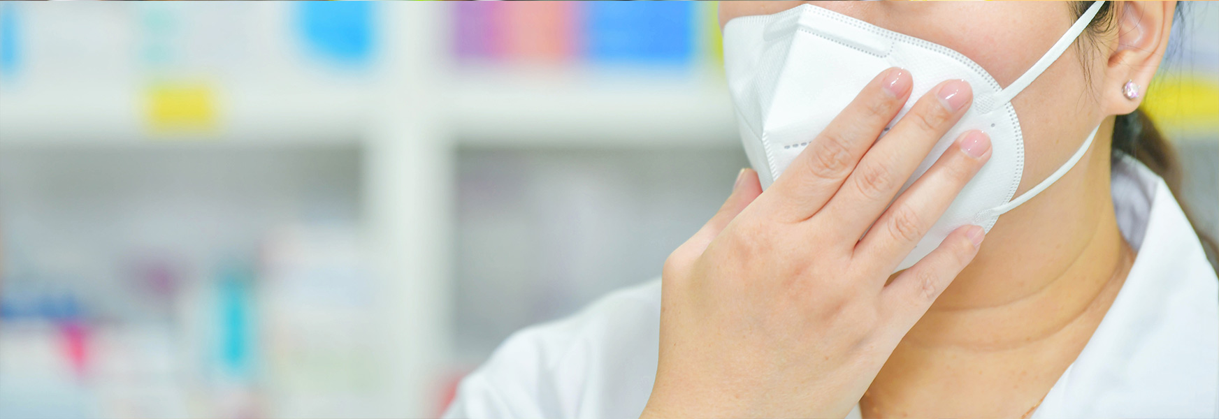 pharmacy worker adjusting N95 mask