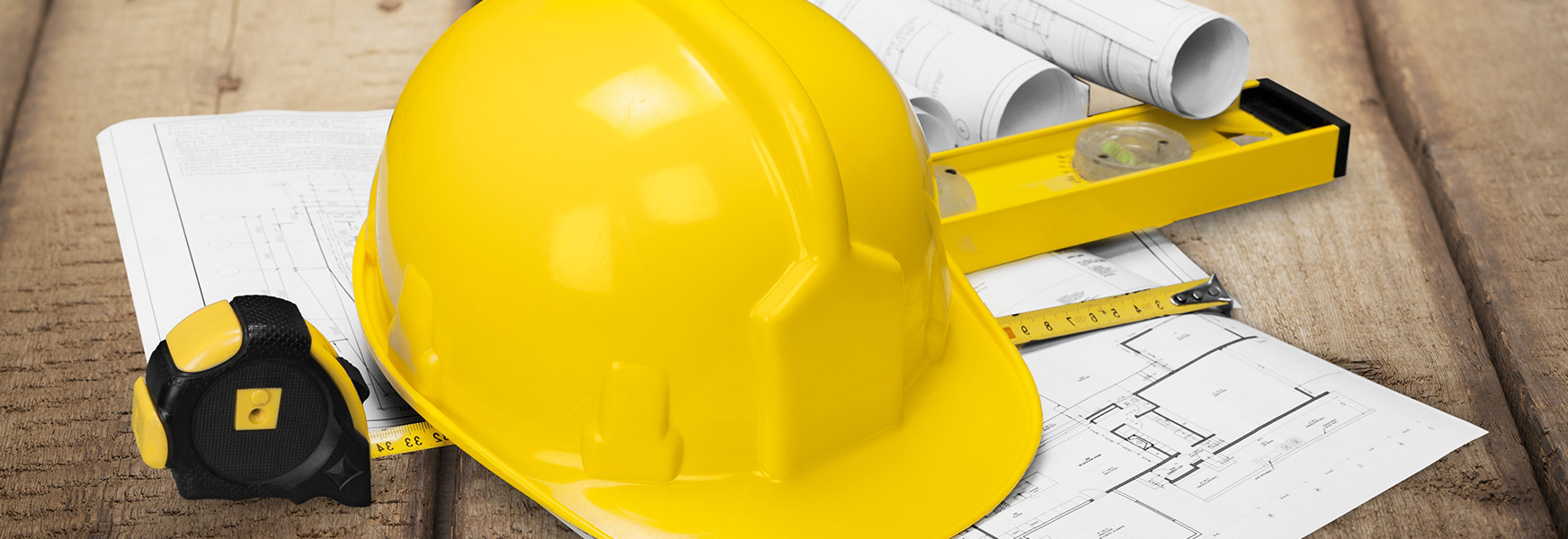 construction hard hat, building plans and tape measurer